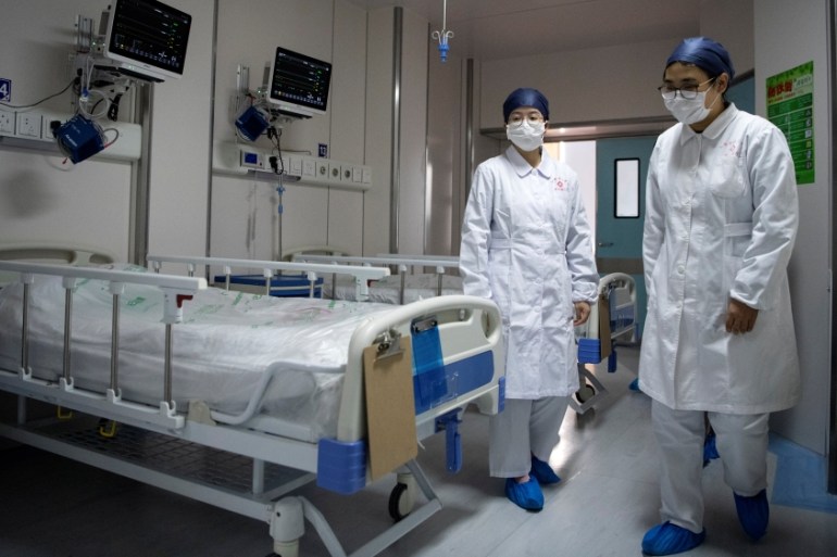 Nurses walk inside a quarantine room for coronavirus patients at finished but still unused building A2 of the Shanghai Public Clinical Center, in Shanghai