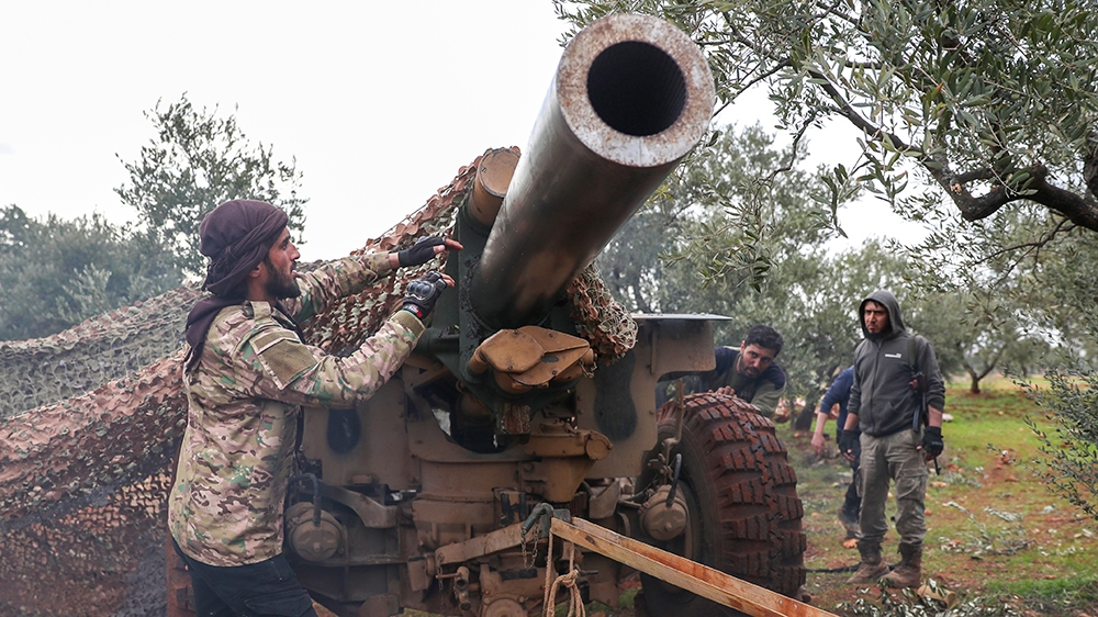 Turkish-backed Syrian rebel fighters cover their artillery gun in the town of Sarmin, about eight kilometres southeast of the city of Idlib in northwestern Syria, on February 24, 2020, as they take pa