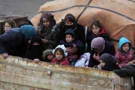 Syrians sit in the back of a truck as they flee the advance of the government forces in the province of Idlib, Syria, towards the Turkish border, Thursday, Jan. 30, 2020. Warplanes struck a town in a