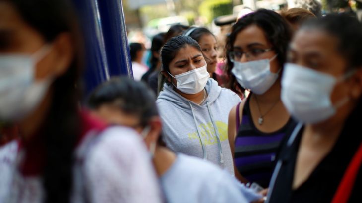 People wearing protective face masks wait in line outside the National Institute of Respiratory Diseases where a patient who tested positive for coronavirus is being treated, according to local author