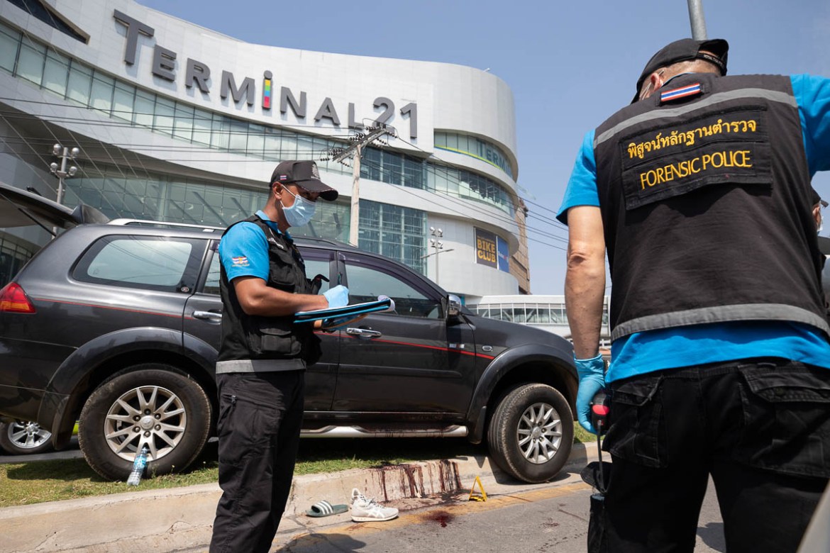 Forensic officers inspect a shooting scene outside the Terminal 21 Korat mall in Nakhon Ratchasima, Thailand, Sunday, Feb. 9, 2020. Thai officials say a soldier who went on a shooting rampage and kill