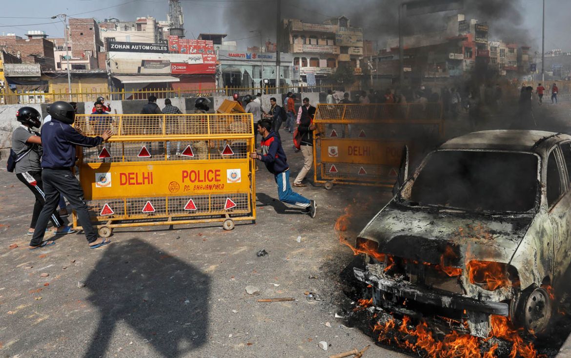 People supporting a new citizenship law push police barricades during a clash with those opposing the law in New Delhi India, February 24, 2020. REUTERS/Danish Siddiqui