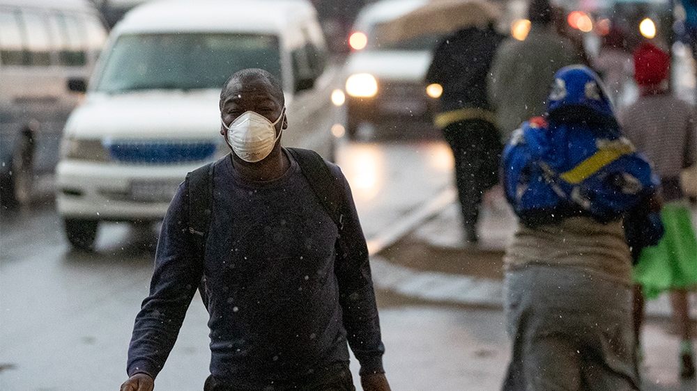 A man wearing a mask, walks on the street in Tembisa, east of Johannesburg, South Africa, Monday, March 23, 2020. South Africa, Africa's most industralized economy and a nation of 57 million people, w