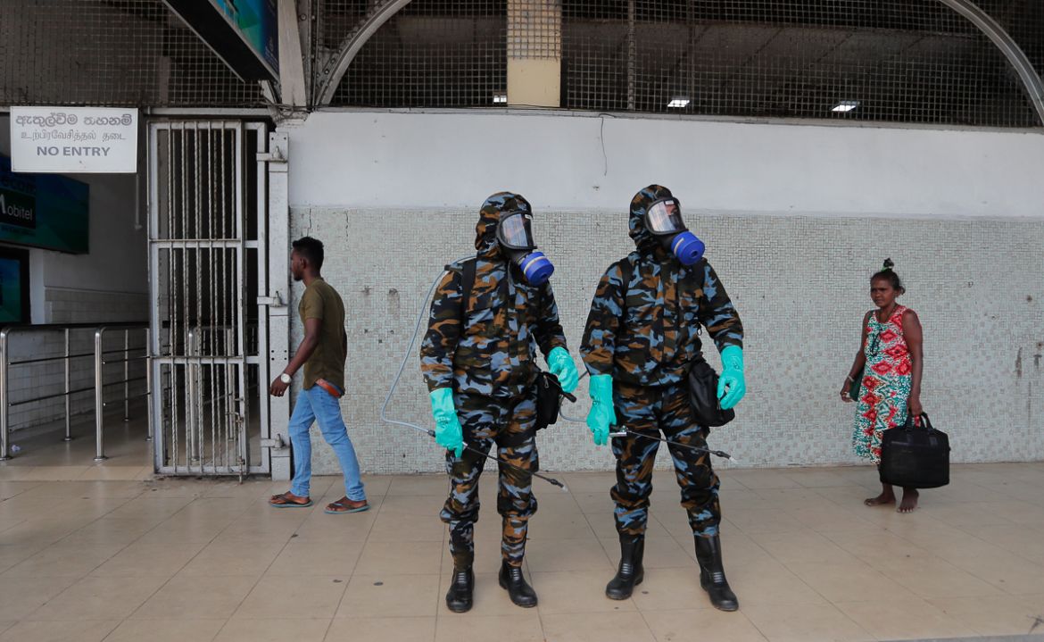 Sri Lankan government soldiers in protective clothes prepare to spray disinfectant inside a railway station in Colombo, Sri Lanka, Wednesday, March 18, 2020. For most people, the new coronavirus cause