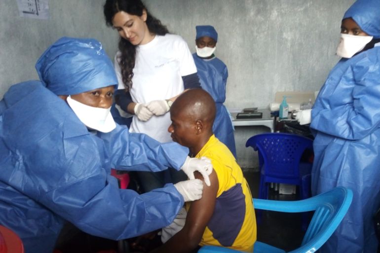 This hand out picture released by Doctors Without Borders (MSF) on November 14, 2019, shows Muliirwa Mulire (C) receiving his first injection of the new Ebola vaccine in the MSF facilities in the Nort