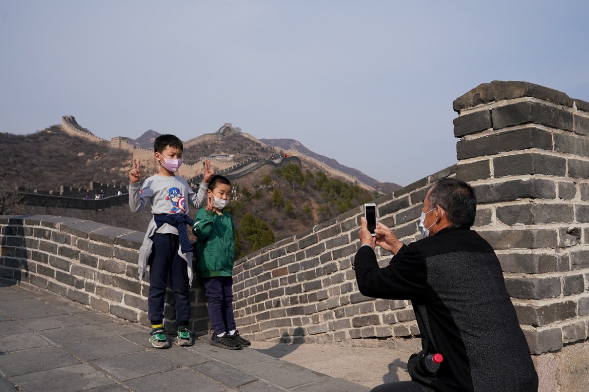BEIJING, CHINA - MARCH 24: Two chinese kids wear protective masks as they visit the almost empty Badaling Great Wall on March 24, 2020 in Beijing, China. Affected by the new coronavirus covid-19, the