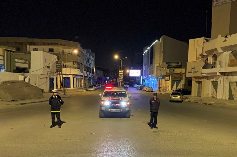 Police officers stand in the middle of the road during a curfew, imposed as part of precautionary measures against coronavirus disease (COVID-19), in Misrata, Libya March 22, 2020. Picture taken March