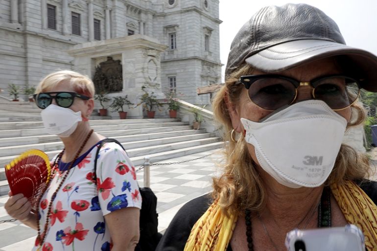 epa08302972 Tourists wear protective face mask as they wait near Victoria Memorial in Kolkata, India, 18 March 2020. The Bengal government has issued advisory notices for public places, to reduce crow