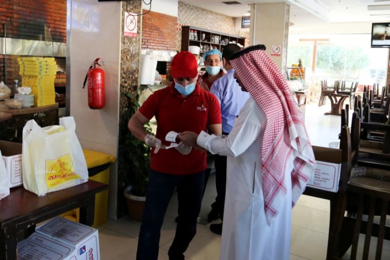 A Saudi man requests a meal from a restaurant worker after the customers were prevented from sitting in restaurants, following the outbreak of coronavirus diseases (COVID-19), in Riyadh