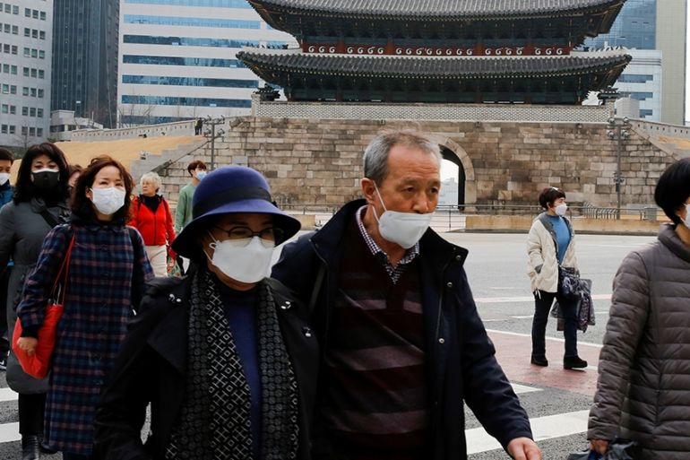 People wearing masks to prevent contracting the coronavirus cross a street in downtown Seoul, South Korea March 9, 2020. REUTERS/Heo Ran