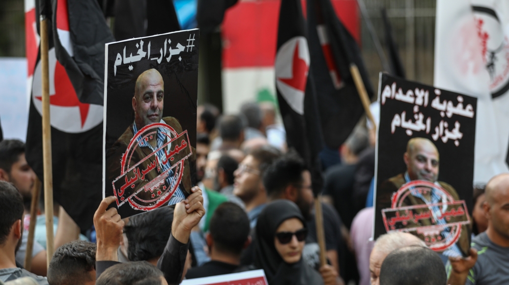 Former detainees of the pro-Israel South Lebanon Army (SLA) militia hold posters depicting former SLA member Amer al-Fakhoury during a demonstration denouncing his return and entry outside the Justice