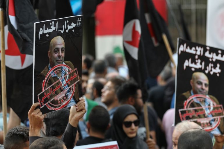 Former detainees of the pro-Israel South Lebanon Army (SLA) militia hold posters depicting former SLA member Amer al-Fakhoury during a demonstration denouncing his return and entry outside the Justice