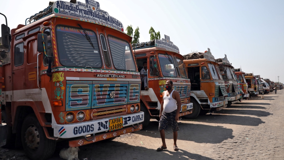 A man walks past parked supply trucks at a yard during a 21-day nationwide lockdown to limit the spreading of coronavirus disease (COVID-19), on the outskirts of Kolkata