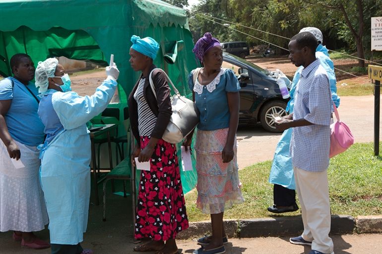 Health workers screen people visiting a public hospital in Harare, Zimbabwe ,Saturday, March, 21, 2020 . Zimbabwe announced its first case of coronavirus,in one of Africa''s most visited tourist