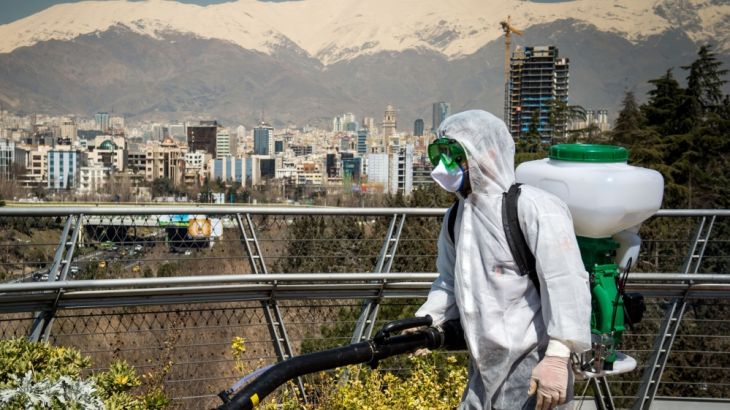 A firefighter wearing protective clothing, mask and goggles, sprays disinfectant on Tabia''t bridge pedestrian overpass in Tehran, Iran, on Monday, March 9, 2020. The country’s health care system, burd