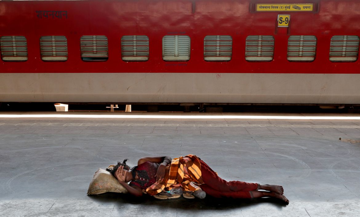 FILE - In this Monday, March 23, 2020, file photo, a homeless woman sleeps on a deserted platform of Lokmanya Tilak train terminus in Mumbai, India. India''s colossal passenger railway system has come
