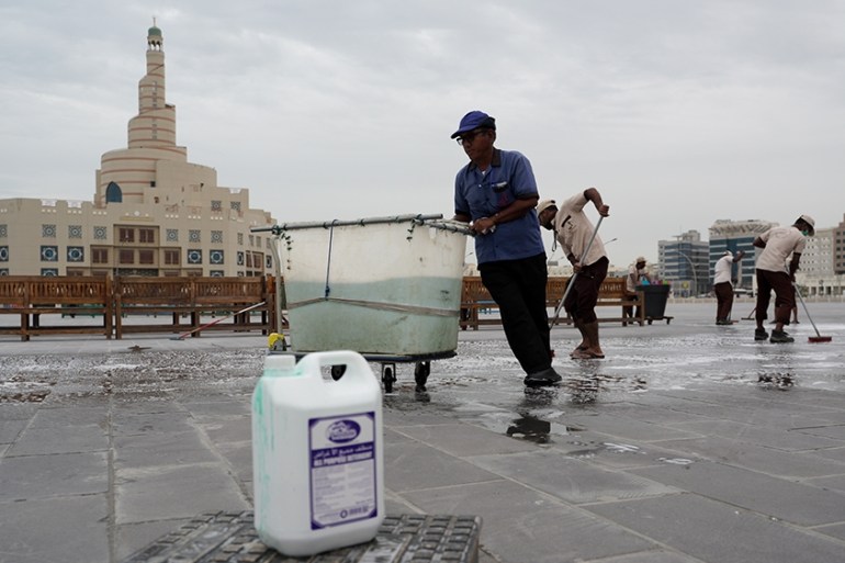 Workers use detergent and disinfectant to clean the pavement in Souq Waqif as the number of coronavirus cases has increased by 17, Doha, Qatar on Saturday, March 14, 2020 [Sorin Furcoi/Al Jazeera]