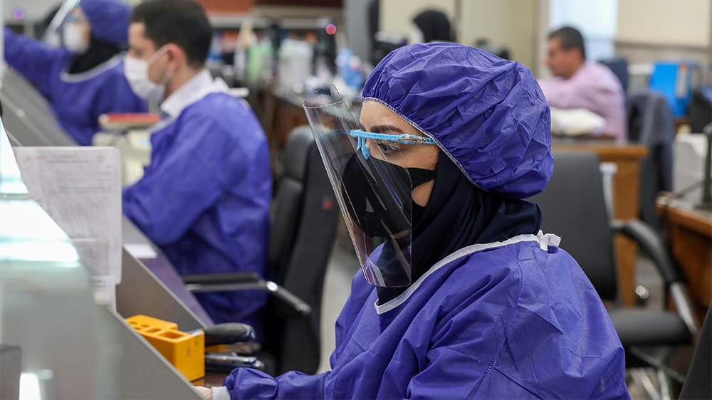 Bank employees wear protective face masks and clothes, following the outbreak of coronavirus, during the work in Tehran, Iran March 17, 2020. WANA (West Asia News Agency)/Ali Khara via REUTERS ATTENTI