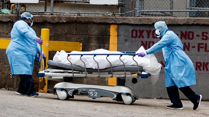 epa08333012 Medical professionals tend to a body on a hospital gurney as it is moved to be temporarily stored in a mobile morgue, put in place due to lack of space at the hospital, outside of the Broo