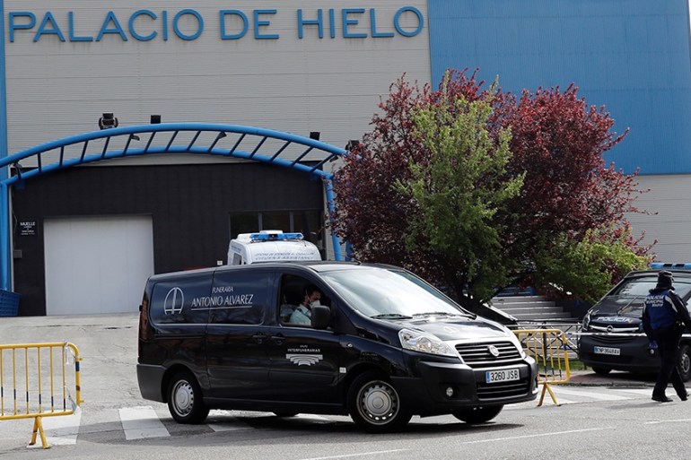 epa08317566 A hearse (C) leaves Palacio de Hielo ice skating center and shopping mall in Madrid, Spain, 24 March 2020. The facilities will be used as a morgue for coronavirus fatalities amid coronavir