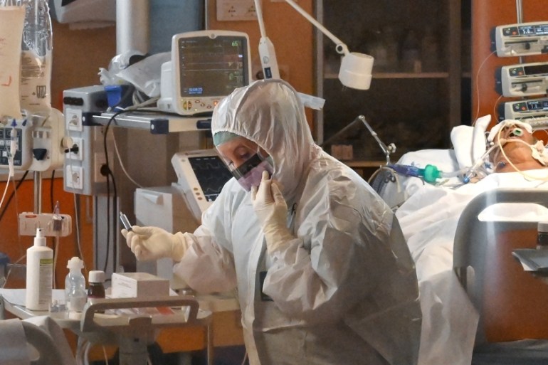 A medical worker wearing a protective gear works by a patient (Rear R) on March 24, 2020 at the new COVID 3 level intensive care unit for coronavirus COVID-19 cases at the Casal Palocco hospital near