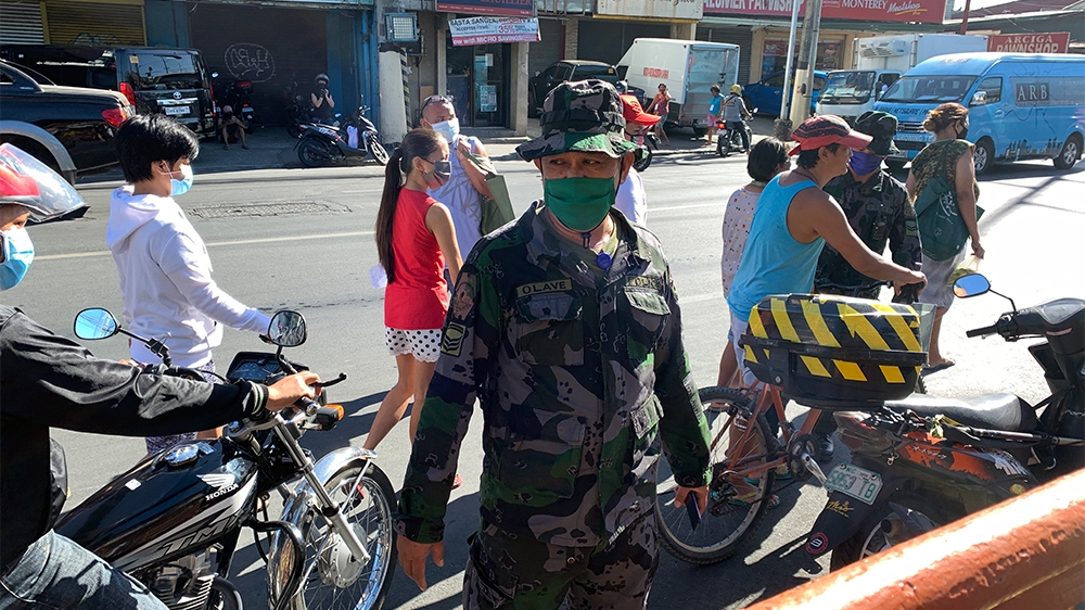 epa08317098 A soldier wearing a facemask stands guard in the street amid the ongoing coronavirus pandemic crisis, in Las Pinas, south of Manila, Philippines, 24 March 2020. According to the Department