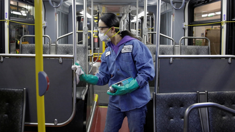 FILE PHOTO: Vehicle Maintenance Utility Service Worker Thiphavanh 'Loui' Thepvongsa wipes down an off-duty bus with a disinfectant during a routine cleaning at the King County Metro Atlanti