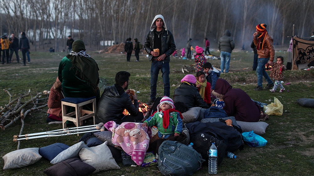 epa08262947 A group of migrants rests near Meric (Evros) River as they wait to cross to reach Greece at the Turkish-Greek border, in Edirne, Turkey, 01 March 2020. Thousands of refugees and migrants a