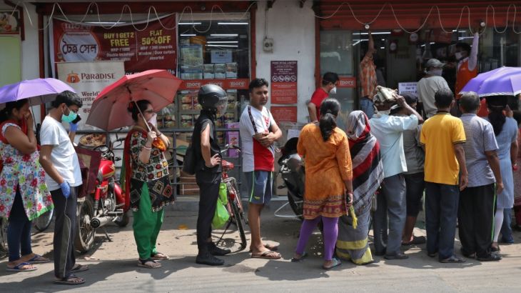 People queue to buy grocery items outside a store before the start of lockdown by West Bengal state government, to limit the spreading of coronavirus disease (COVID-19), in Kolkata