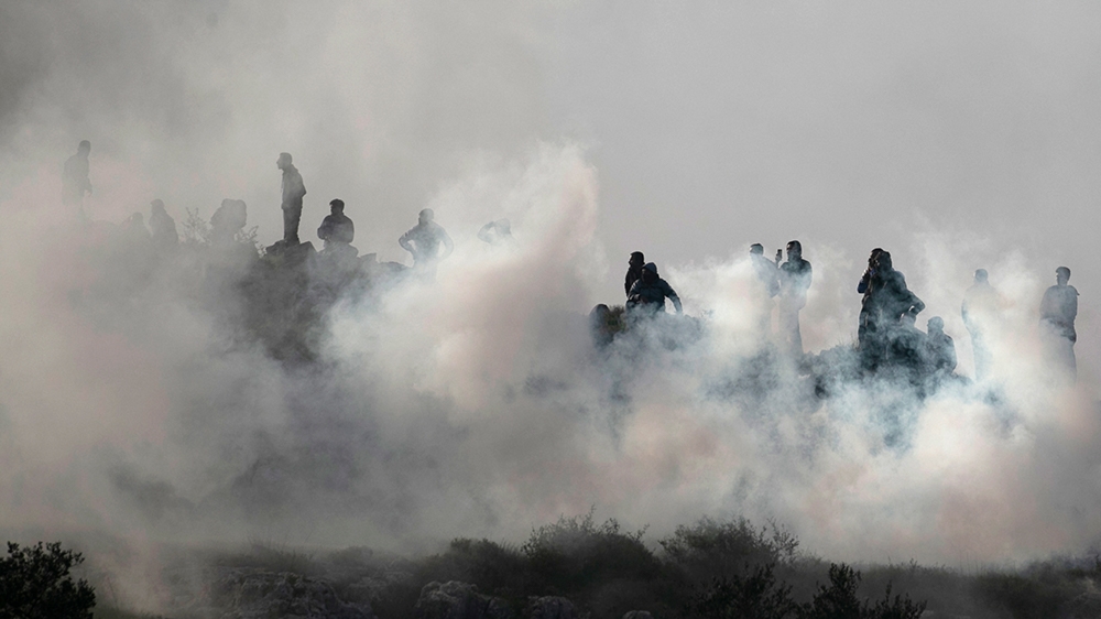 Palestinian youths stand amidst tera gas smoke during clashes with Israeli forces in a village south of Nablus in the occupied West Bank on March 11, 2020. (Photo by JAAFAR ASHTIYEH / AFP)