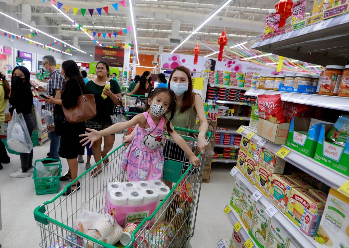 A family wears protective face masks due to the coronavirus outbreak, as they line up at counters in a super market in Bangkok, Thailand March 16, 2020. REUTERS/Soe Zeya Tun - RC21LF9EZ7SE