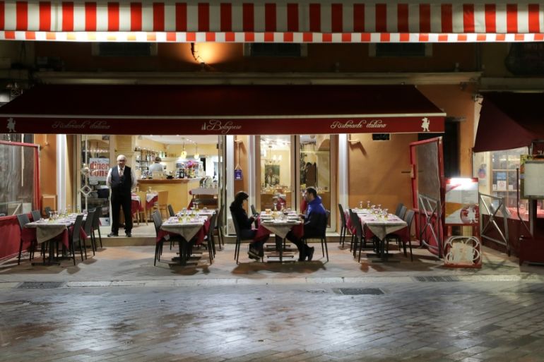 A couple sits in a restaurant, as France''s Prime Minister announced to close most all non-indispensable locations, notably cafes, restaurants, cinemas, nightclubs and shops from midnight in Nice