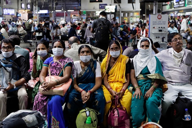 Indians waiting at a train station wear protective masks as a precaution against a new virus outbreak in Mumbai, India, Tuesday, March 17, 2020. For most people, the new coronavirus causes only mild o