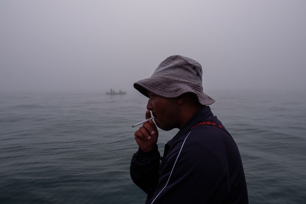 06 December 2019:Gregory Stofberg takes a smoke after all the ring nets are cast. “Our livelihoods come from the sea”, he says. “We don’t have any income. No fish, no pay.” Since the corona outbreak
