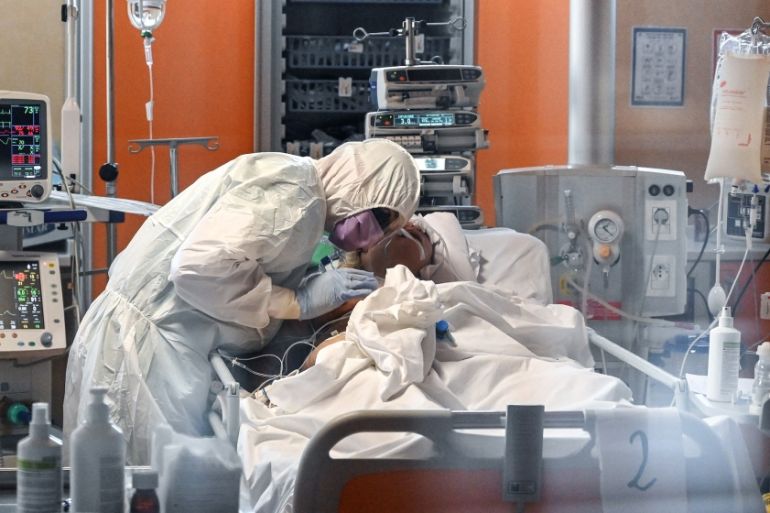 A medical worker in protective gear tends to a patient on March 24, 2020 at the new COVID 3 level intensive care unit for coronavirus COVID-19 cases at the Casal Palocco hospital near Rome, during the