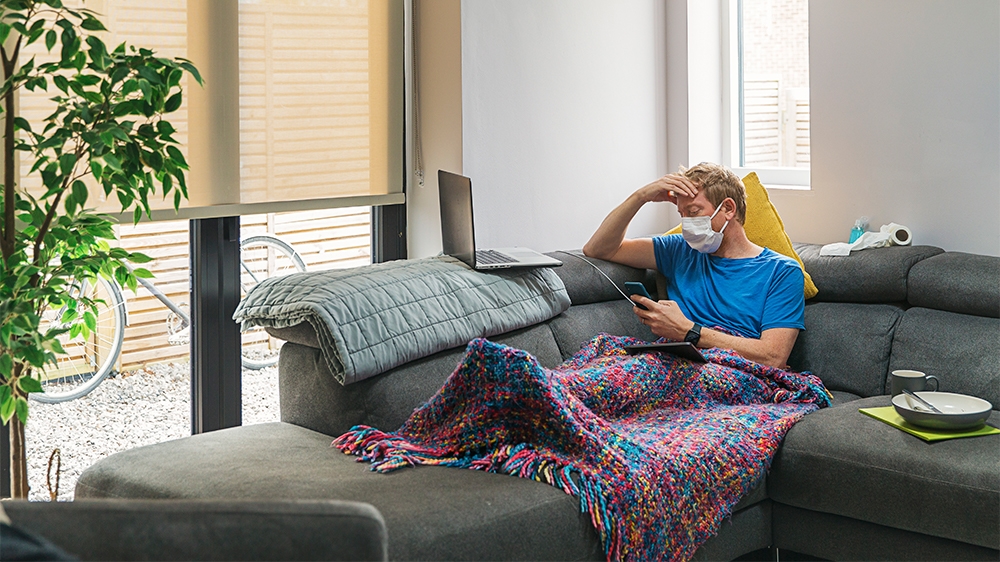Man in self isolation on the sofa with the flu [Getty Images]
