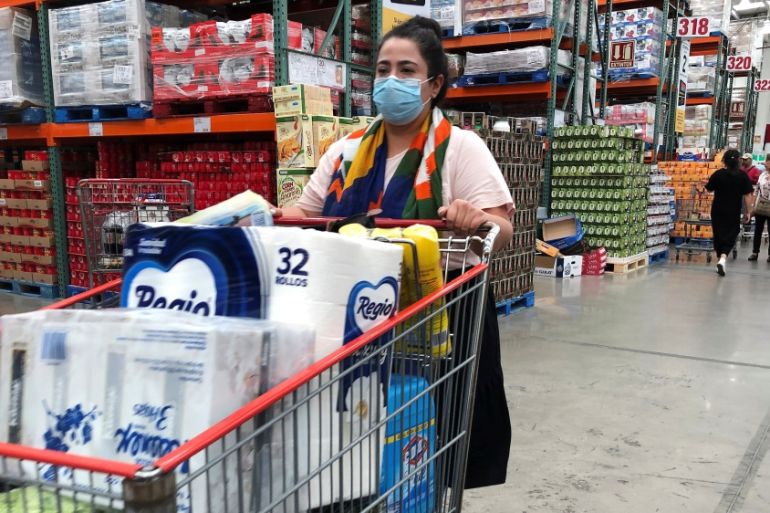 A woman wears a protective mask as she waits to pay at a supermarket during an outbreak of the coronavirus (COVID-19), in Mexico City