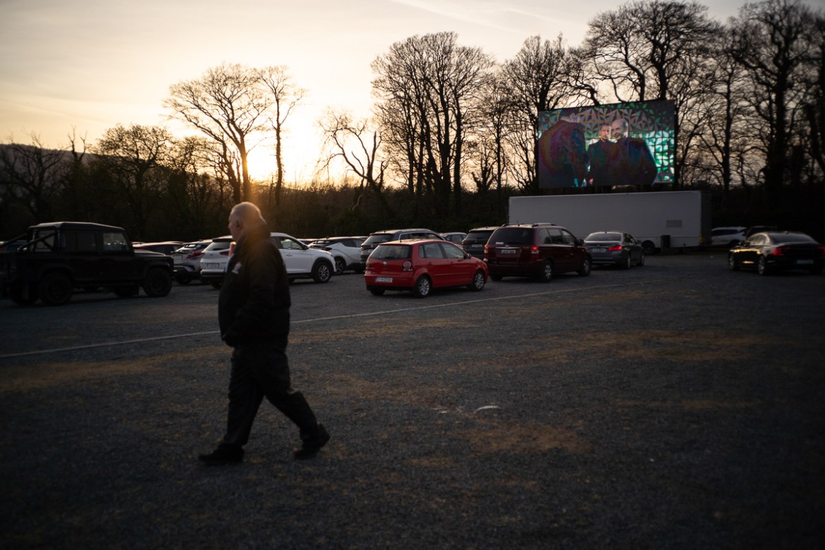 Although a few choose to briefly exit their cars, staff at Retro Drive-In Movies stay vigilant making sure people maintain a safe social distance. Dublin, Ireland - March 24, 2020.