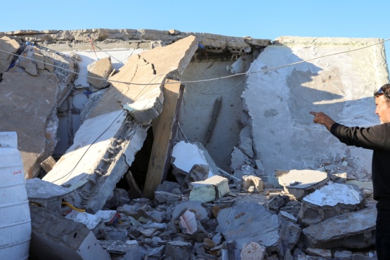 A man inspects a damaged house after shells fell on a residential area, in Abu Slim district south of Tripoli