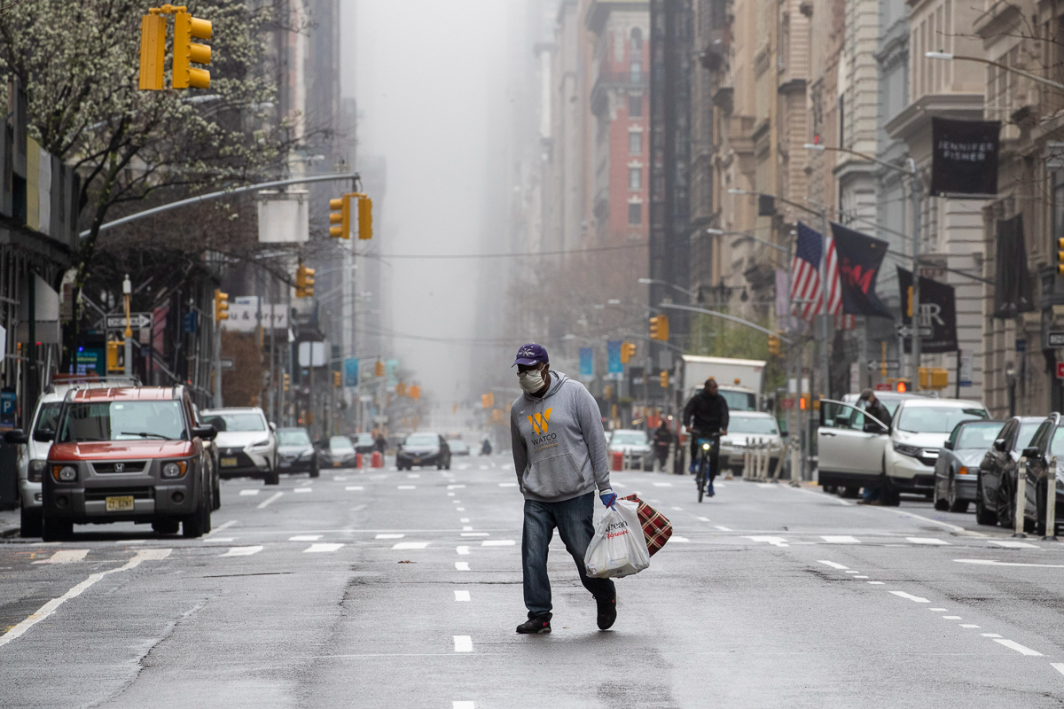 Um homem usando uma máscara facial atravessa o meio da 5ª Avenida em Midtown Manhattan em Nova York, domingo, 29 de março de 2020. (AP Photo / Mary Altaffer)