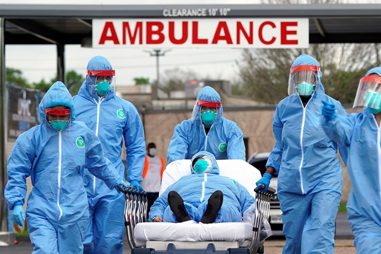 A person is taken on a stretcher into the United Memorial Medical Center after going through testing for COVID-19 Thursday, March 19, 2020, in Houston. People were lined up in their cars in a line tha