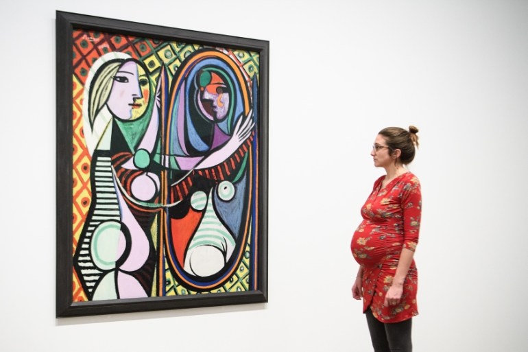 A pregnant woman looks at "Girl before a Mirror" by Pablo Picasso at the Tate Modern on March 6, 2018 in London, England. "Picasso 1932: Love, Fame and Tragedy" is the first solo exhibition at Tate Mo