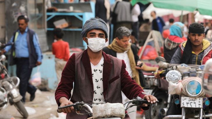 A man wears a protective face mask as he rides a motorcycle amid fears of the spread of the coronavirus disease (COVID-19) in Sanaa