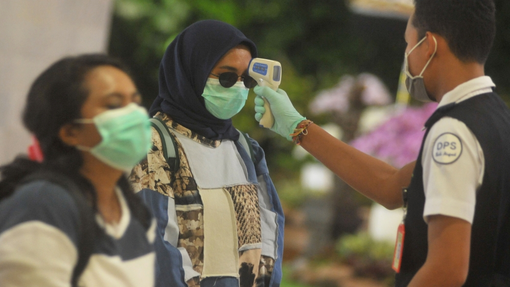 An officer uses a thermal scanner in I Gusti Ngurah Rai International airport after Indonesia confirmed new cases of coronavirus disease (COVID-19) in Denpasar, Bali