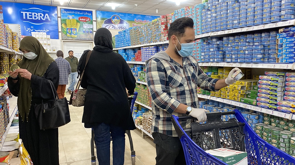 Libyans, wearing protective face masks, shop at a supermarket in the capital Tripoli on March 15, 2020. - The UN-recognised government in divided and war-torn Libya has said it will close from March 1