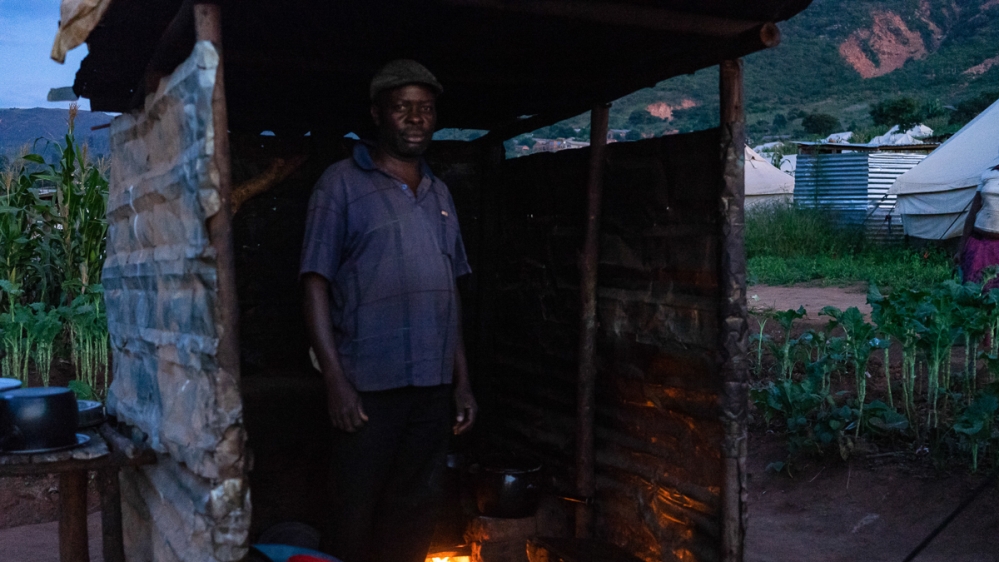 Godfrey Muparingwe in a makeshift kitchen where he and his family prepare meals. [Tendai Marima/Al Jazeera]