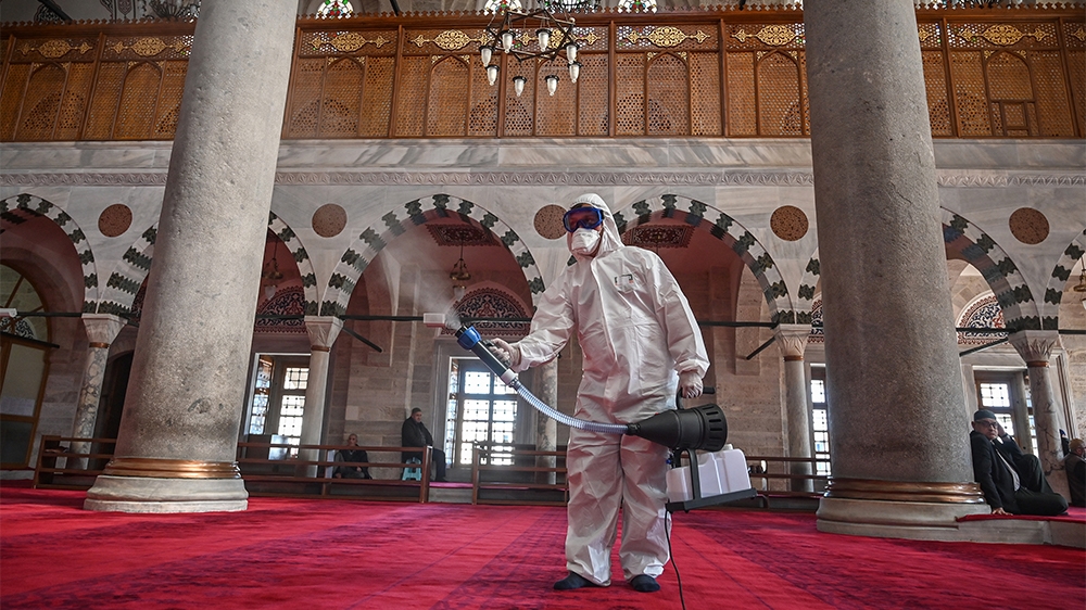 A member of Istanbul's Municipality disinfects the Mihrimah Sultan Mosque in Istanbul to prevent the spread of the COVID-19, the novel coronavirus, on March 13, 2020. - Turkey said on March 12, 2020 i
