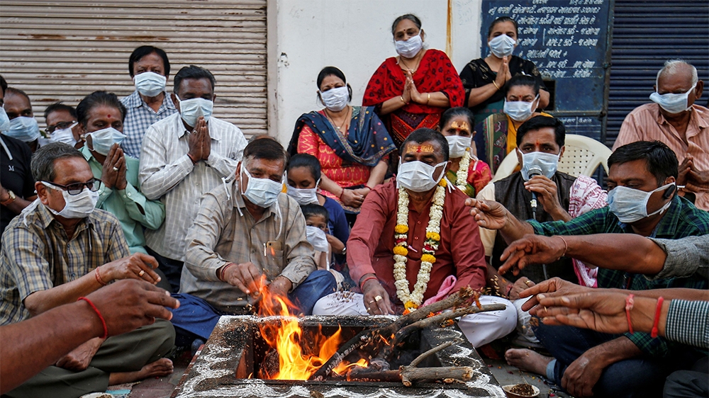 Hindu residents wearing protective masks perform prayers for the protection against coronavirus disease (COVID-19), outside a temple, in Ahmedabad, India, March 13, 2020. REUTERS/Amit Dave