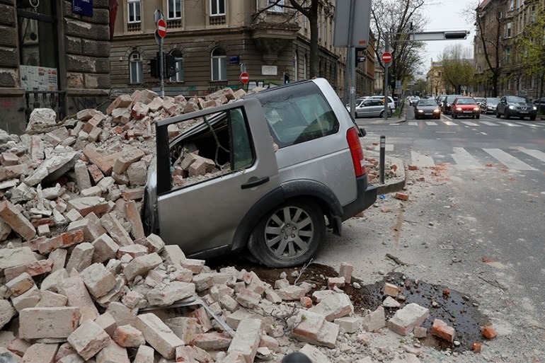 A car is crushed by falling debris after an earthquake in Zagreb, Croatia, Sunday, March 22, 2020. A strong earthquake shook Croatia and its capital on Sunday, causing widespread damage and panic. (AP