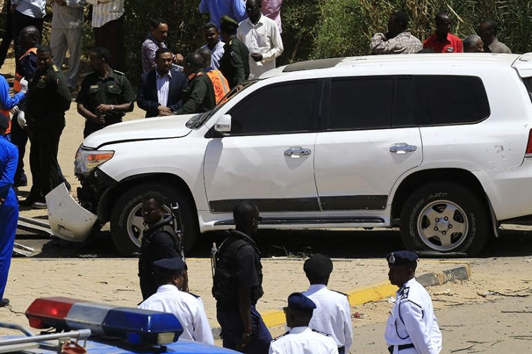 Sudanese rescue teams and security forces gather next to a damaged vehicle at the site of an assassination attempt against Sudan''s Prime Minister Abdalla Hamdok, who survived the attack with explosive